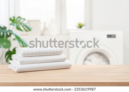 Stack of clean laundry bedding sheets on table in bathroom