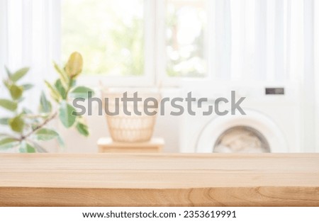 Background for design with empty table on blur laundry room Royalty-Free Stock Photo #2353619991