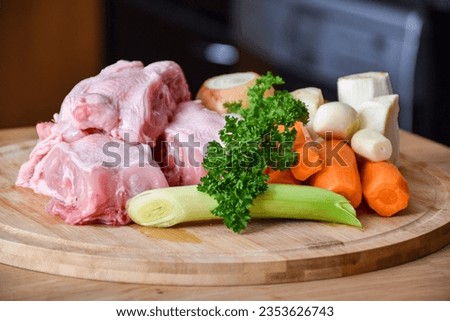 Ingredients for chicken stock from chicken backs for soup. Soup with meat, carrots, celery, parsley, garlic, pork, parsley.
