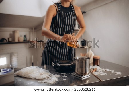 Woman making aromatic candles at white table indoors, closeup. High quality photo