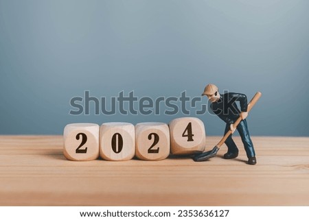 Wooden blocks with change 2023 to 2024 number with mini worker.