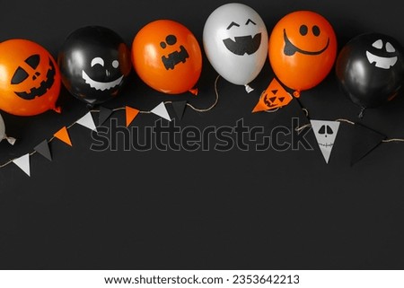 Funny Halloween balloons and garland on black background Royalty-Free Stock Photo #2353642213