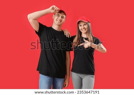 Young couple in black t-shirts on red background
