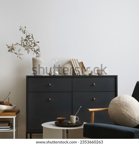 Creative composition of living room interior with navy blue commode, velvet armchair, round pillow, coffee table, decoration and personal accessories. Stylish home decor. Template.