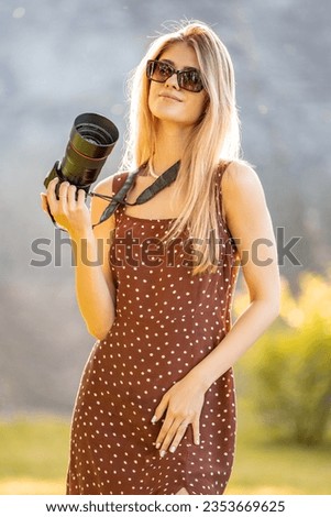 Woman is a professional photographer with dslr camera, outdoor and sunlight
