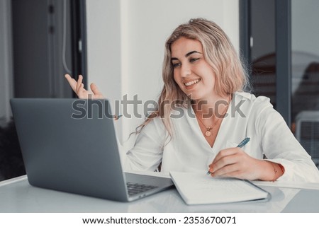 Happy caucasian young girl student watch webinar listen online course communicate by conference video call e learn language in app laugh study with teacher lesson look at laptop at home Royalty-Free Stock Photo #2353670071