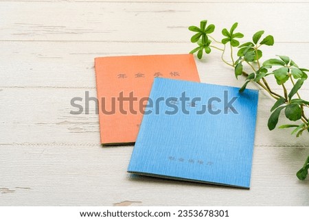 Japanese pension insurance booklet on wooden table. (Written 'pension book') Royalty-Free Stock Photo #2353678301
