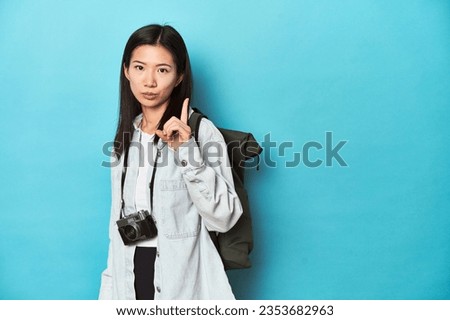 Young Asian traveler ready to capture adventures, having some great idea, concept of creativity. Royalty-Free Stock Photo #2353682963