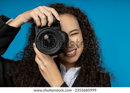 A girl in a black suit with a camera