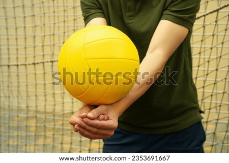 Young man and blank yellow volleyball ball