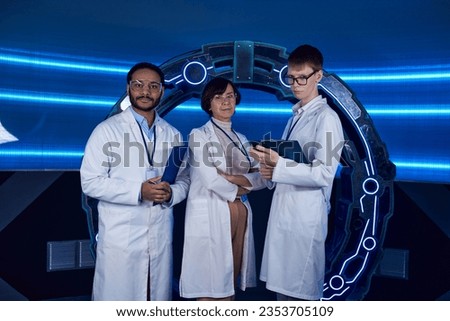 future-oriented multiethnic scientists looking at camera near innovative device in discovery center Royalty-Free Stock Photo #2353705109