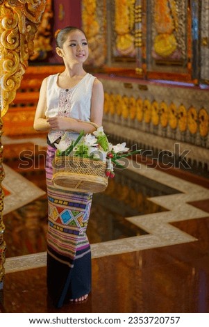 Pretty girl wearing beautiful traditional Thai dresses in Asian tradition Buddhism to make merit at Wat Sri Don Moon Temple in Chiang Mai, Thailand. Concept religion Thai teenager culture lifestyle.