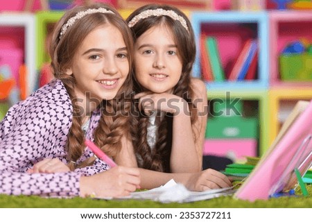 Two school age kids doing their homework on floor at home. Brother and sister siblings children drawing together, preparing for school lesson. Homeschool concept. High quality photo
