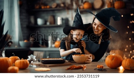 Mother and her daughter having fun at home. Happy Family preparing for Halloween. Mum and child cooking festive fare in the kitchen. Royalty-Free Stock Photo #2353731119