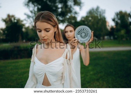  Two young women are meditating in nature. High quality photo