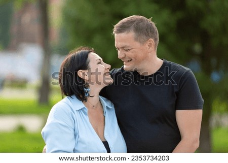 Husband and wife walking in the park, laughing happily, hugging