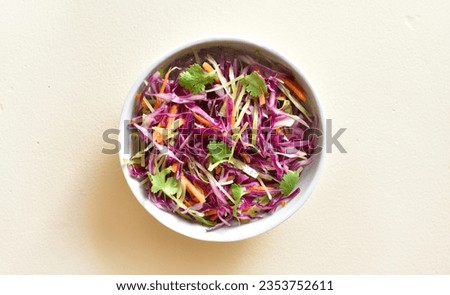 Red cabbage salad in bowl over light stone background. Vegetarian vegan or healthy natural food concept. Top view, flat lay Royalty-Free Stock Photo #2353752611