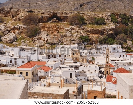 Lindos town in Greece aerial view in cloud summer day, white houses in Rhodes island , cityscape viewpoint traditional greek architecture, famous landmark and touristic destination concept