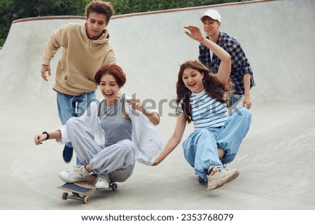 Group of cheerful friends, teens spending good time together on skatepark, skateboarding, laughing. Joy. Concept of youth culture, sport, dynamic, extreme, hobby, action and motion, friendship