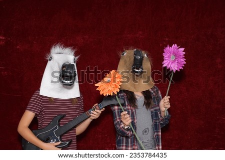 Photo Booth. Unidentifiable People wear Horse Head Masks and pose and play while their pictures are taken in a Photo Booth. Party Photo Booth. Wedding Photo Booth. Holiday. Horsing Around. Fun 
