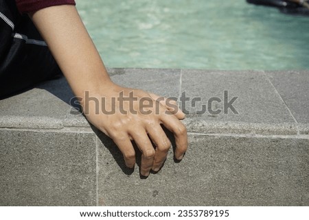 hand holding the edge of the pool. sports break