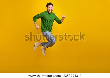 Full body size photo of running crazy young man hurry marathon race high speed jumper high motivation isolated on yellow color background