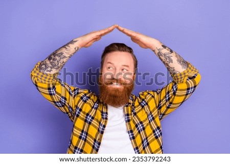 Portrait of minded positive guy look empty space arms make roof above head symbol isolated on purple color background