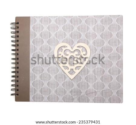 Photo album with grey textile cover,  metal spring, decorated with wooden heart isolated on white background