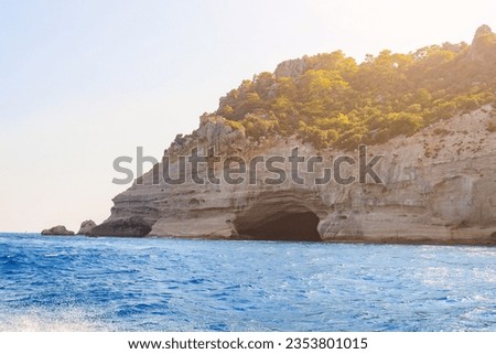 View of the rocky shore from the sea. Background with selective focus and copy space for text. Mediterranean Sea in Turkey. Popular tourist places