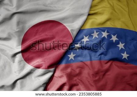 big waving national colorful flag of japan and national flag of venezuela . macro