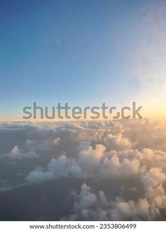 The picture showcases a serene sky with fluffy clouds and a radiant sun. The sun's warm rays peek through the clouds, creating a tranquil and picturesque scene.