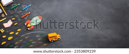 Back to school concept. rocket, bus and pencils over classroom blackboard. Top view