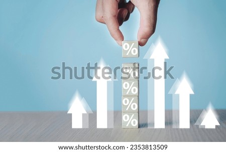 Interest rates and dividends, hand picking wooden blocks with percentage symbol and up arrow, returns on stocks and mutual funds, long term investments for retirement	

