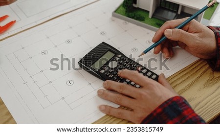 3rd male engineer designing house structure on table in office