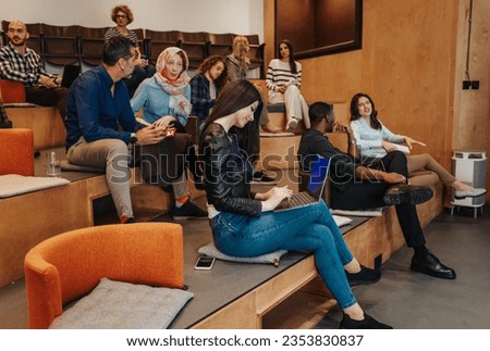 Diverse business start-up team brainstorming at amphitheater in big business center, discussing business ideas Royalty-Free Stock Photo #2353830837