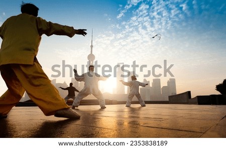 People practice taiji on the bund, oriental pearl tower in the distance,  in Shanghai, China Royalty-Free Stock Photo #2353838189