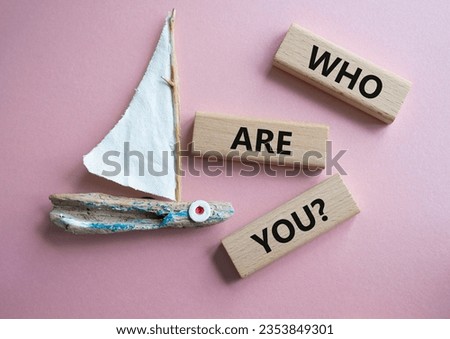 Who are You symbol. Concept words Who are You on wooden blocks. Beautiful pink background with boat. Business and Who are You concept. Copy space.