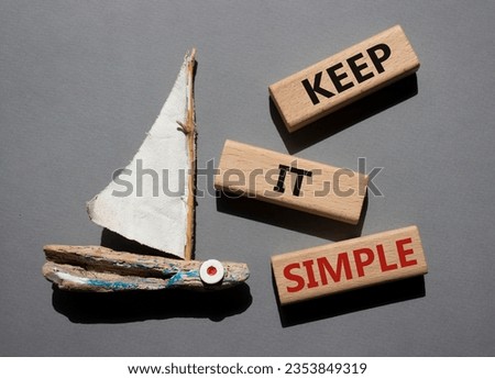 Keep it Simple symbol. Concept words Keep it Simple on wooden blocks. Beautiful grey background with boat. Business and Keep it Simple concept. Copy space.