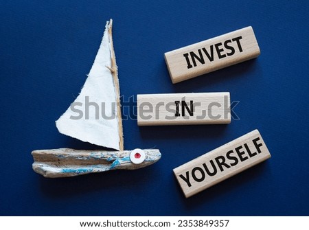 Invest in Yourself symbol. Concept words Invest in Yourself on wooden blocks. Beautiful deep blue background with boat. Business and Invest in Yourself concept. Copy space.