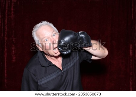 Photo Booth. A man accidently hits himself in the face with a Boxing Glove while having his picture taken in a Photo Booth at a party. Party People Love a Photo Booth. People get pictures printed. 