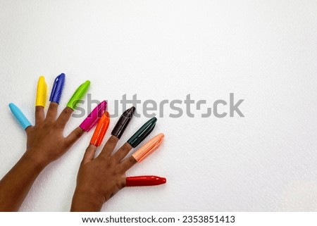 A close-up of ten fingers, each with a colorful pen cap on the end Royalty-Free Stock Photo #2353851413