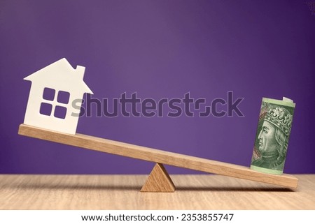 The real estate market in Poland. House symbol and zloty banknote as a symbol of decrease or increase in the cost of housing in Poland. Banner with copy space on purple background.