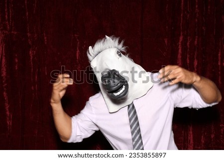Photo Booth. A People wears a Horse Head Masks and poses and plays while their pictures are taken in a Photo Booth. Party Photo Booth. Wedding Photo Booth. Holiday. Horsing Around. Picture Party Fun.
