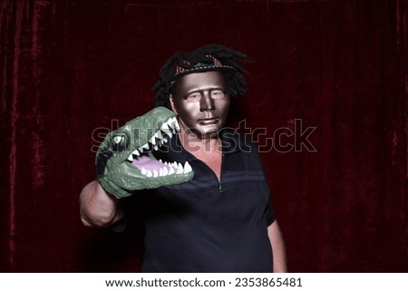 Photo Booth. A man poses for his picture to be taken with Dinosaur Head Puppets while in a Photo Booth. Everyone even Dinosaurs love a Photo Booth at Parties and Events. Pictures get printed for you.