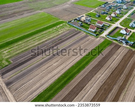 Drone photo of a plowed fields. Aerial view of a farmer's field. A top view of an agricultural field with different cereal crops that creates an abstract picture of multicolored straight lines.