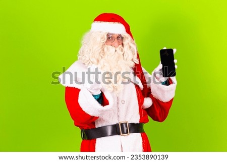Photo of santa claus holding a cell phone with blank screen with free space for text