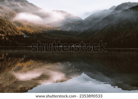 Mountain Reflection on Body of Water Under White Sky at