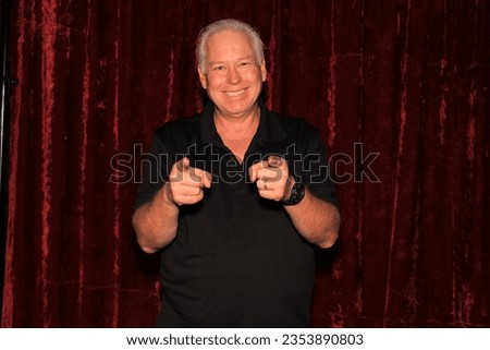 Photo Booth. A man poses and Smiles with props while having his picture taken in a Photo Booth at a party. People love photo booths at parties and events. Everyone gets printed pictures and memories. 
