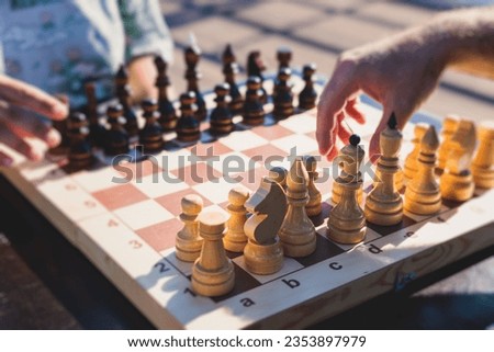 Chess tournament, kids and adults participate in chess match game outdoors in a summer sunny day, players of all ages play, competition in chess school club with chessboards on a table Royalty-Free Stock Photo #2353897979