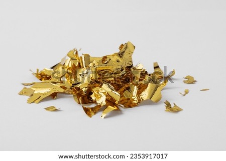 Pile of edible gold leaf on white background Royalty-Free Stock Photo #2353917017